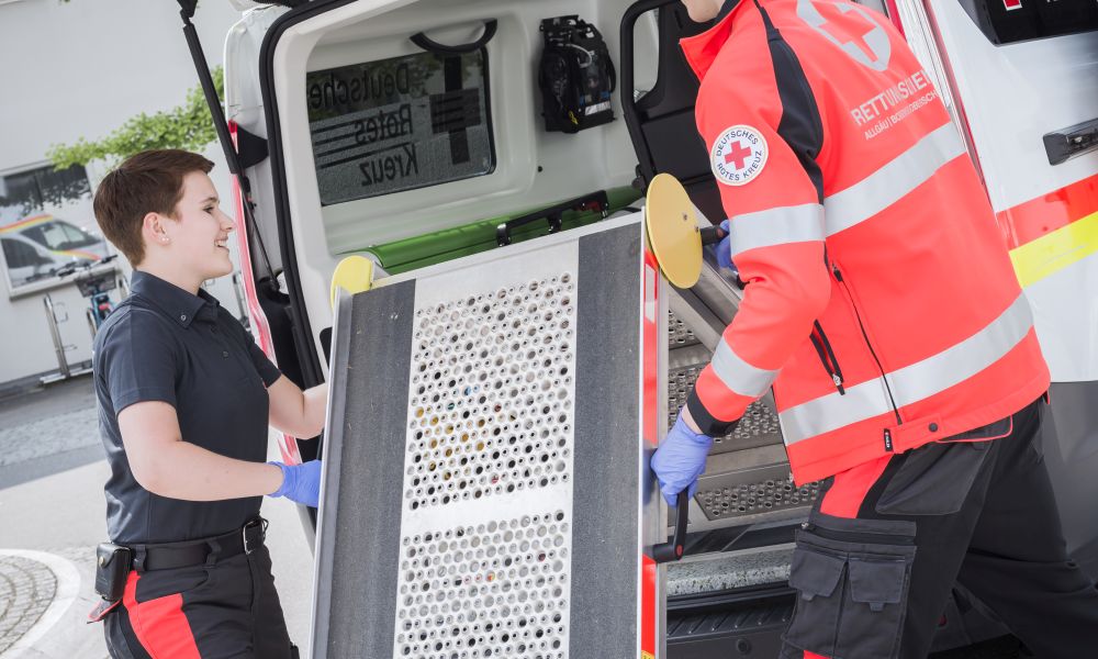 Mitarbeiter klappen die Rampe am KTW ein