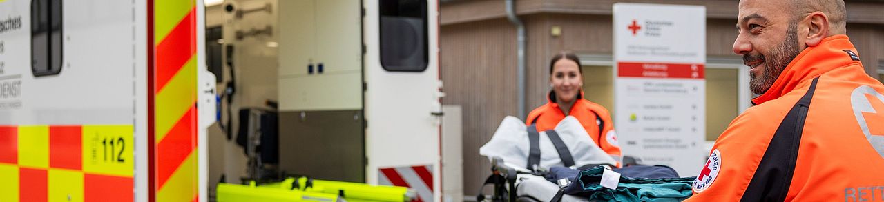 Rettungsdienstpersonal hat Trage aus dem Rettungswagen entladen.