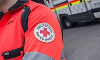 Arm mit rotem Kreuz auf der Einsatzjacke