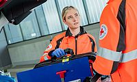 Mitarbeiter des Deutschen Roten Kreuzes an einem Notarzteinsatzfahrzeug